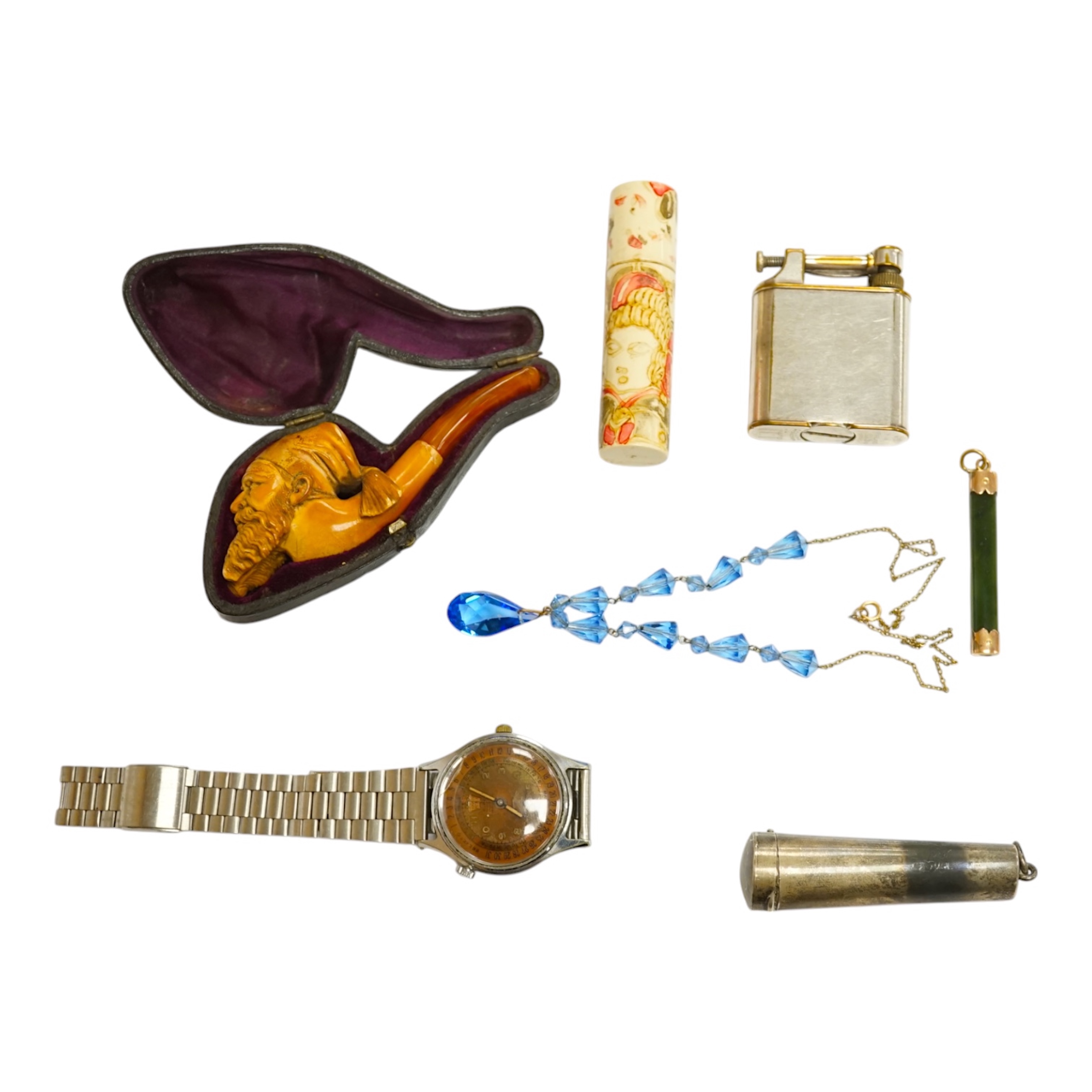 A small group of collectables including a cased Meerschaum pipe, a Dunhill lighter, a yellow metal mounted nephrite pendant, 53mm, yellow metal mounted amber cigarette holder in a silver case, Eloga wrist watch, etc. Con